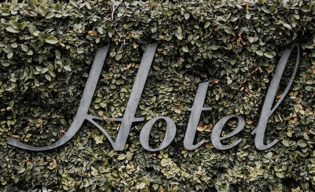 A hotel sign embraced by ivy showcases the impending revolution in the hotel business.