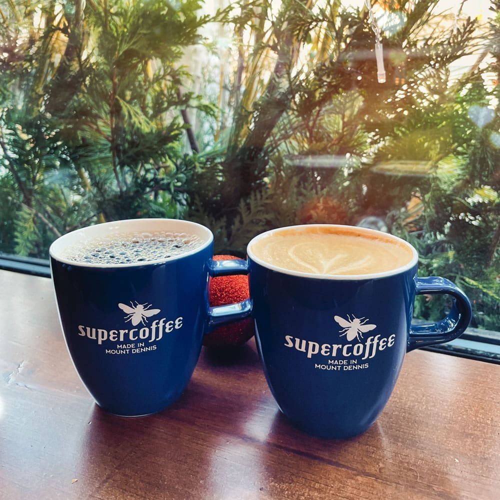 Two cups with the word supercoffee on them.